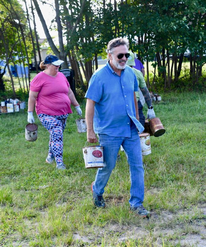 Project manager Mark Chura, front, and Nora Sheehan start the process of removing paint cans from the site.