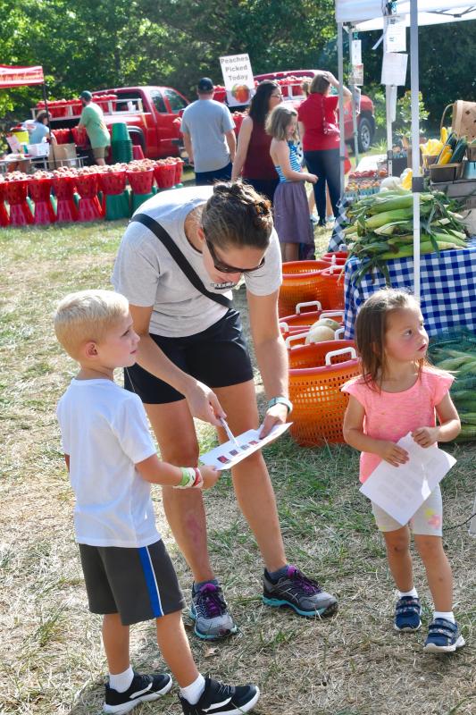 The Dutton family, including Hudson, mom Grace and Hazel, are busy filling out the market scavenger hunt card. They are on the look out for peppers.