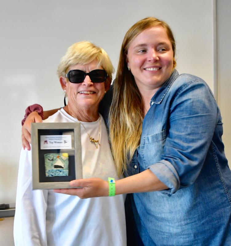 LYC Mobjack skipper Sarah Lester, right, wins the Top Woman Award and gives a hug to organizer Connie Miller.