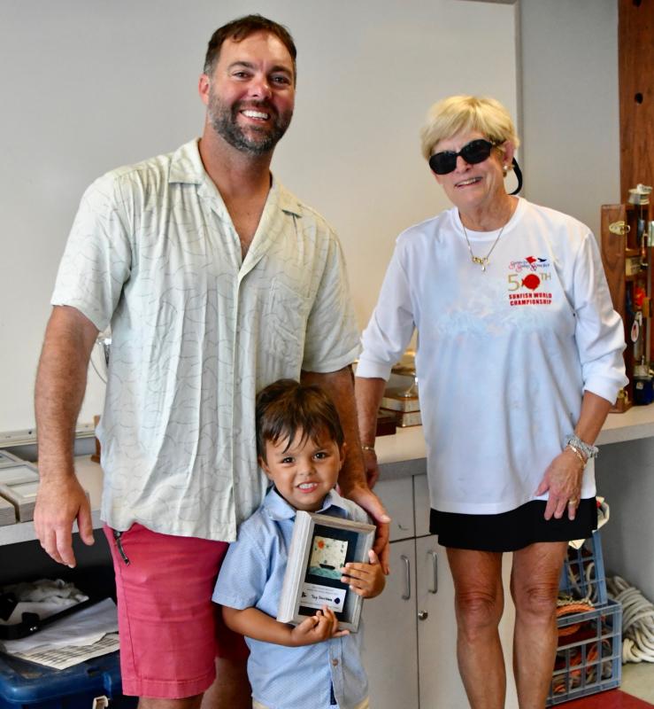 Sunfish sailors Scott, left, and Sav Gaston are presented with the Top Doubles Award by regatta organizer Connie Miller.