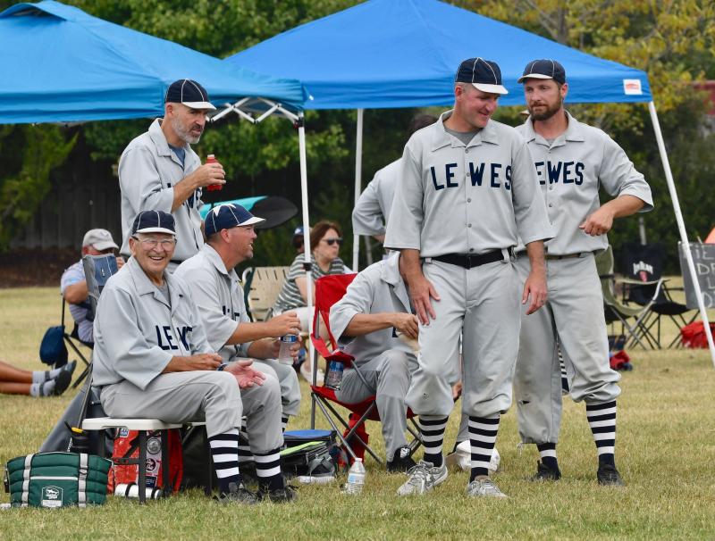 Lewes Base Ball Club players gather around the bench. The squad is keeping the tradition of town teams alive.