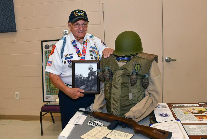 Walt Koopman displays a picture of himself from when he served in the Korean War. After serving, Koopman was the shooting instructor for Elvis Presley.