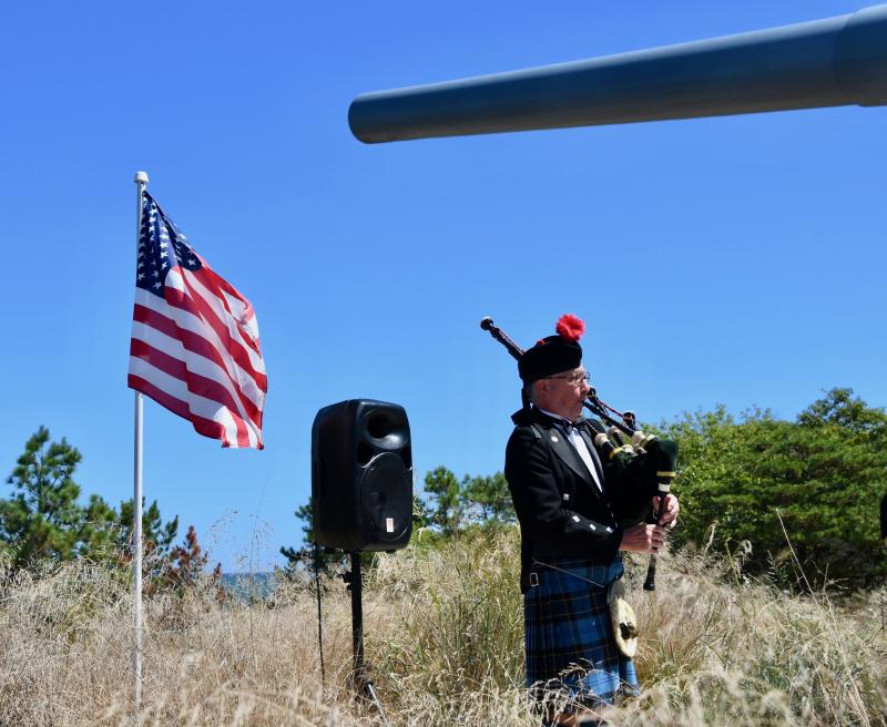 With the USS Missouri gun barrel in the background, Air Force veteran Lani Spahr plays the bagpipes.