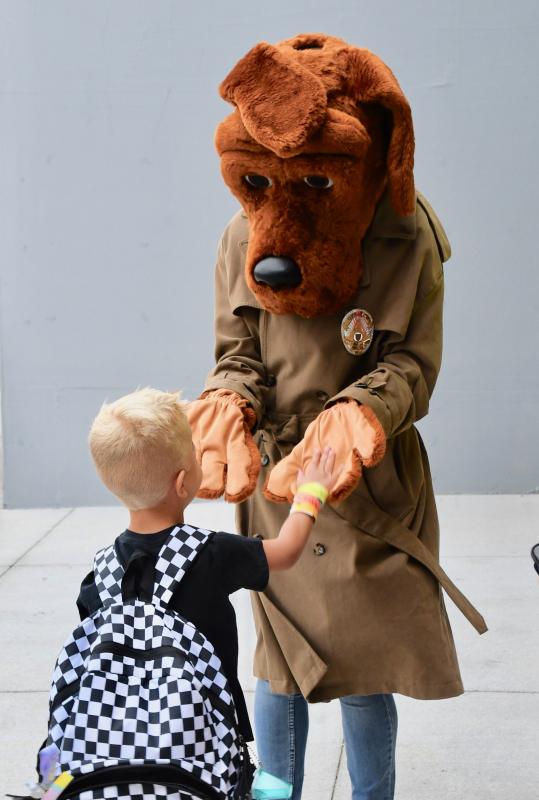 Lewes Elementary School student Cannon Lingo gives McGruff the Crime Dog a handshake as he enters the school. RON MACARTHUR PHOTO