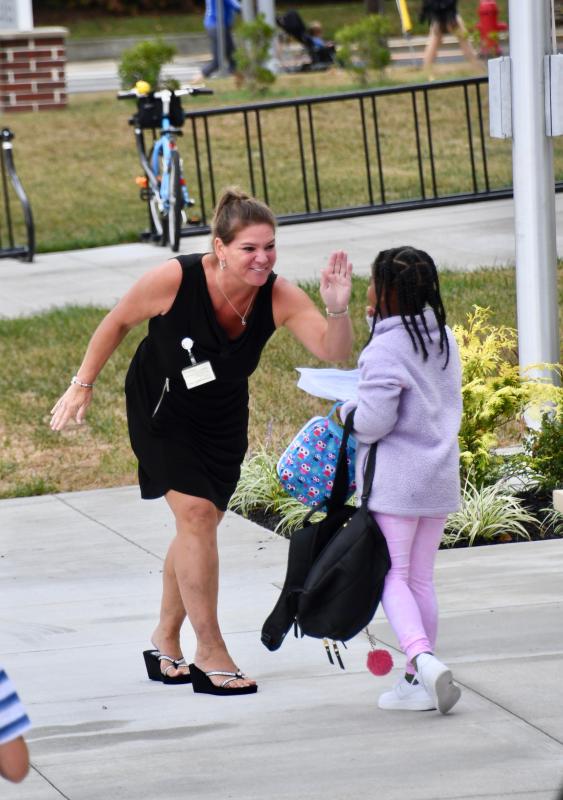 First-grade teacher Candice Ruckle gets a first-day high-five from student Melaney Daisey. RON MACARTHUR PHOTO