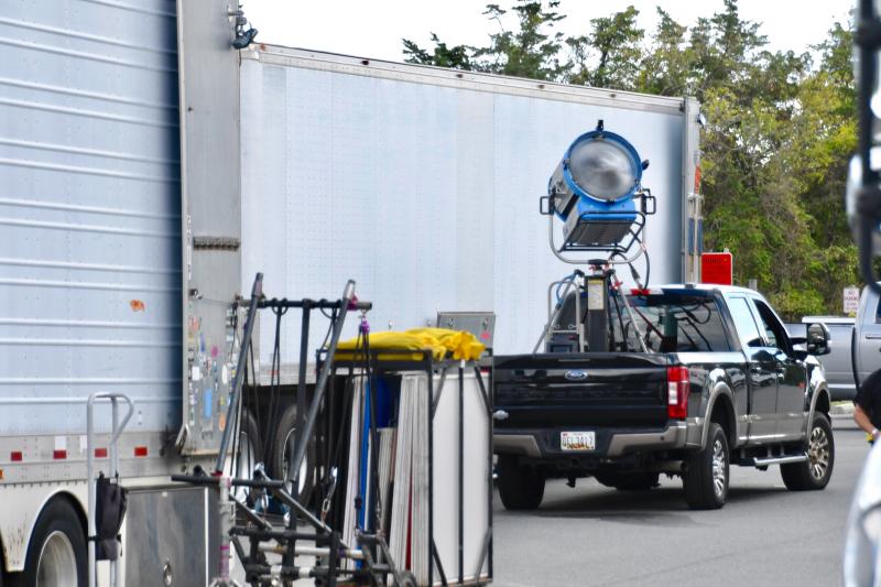 Large film equipment trucks are parked in a section of the Gordons Pond Trail parking lot. The trail remained opened during the filming.