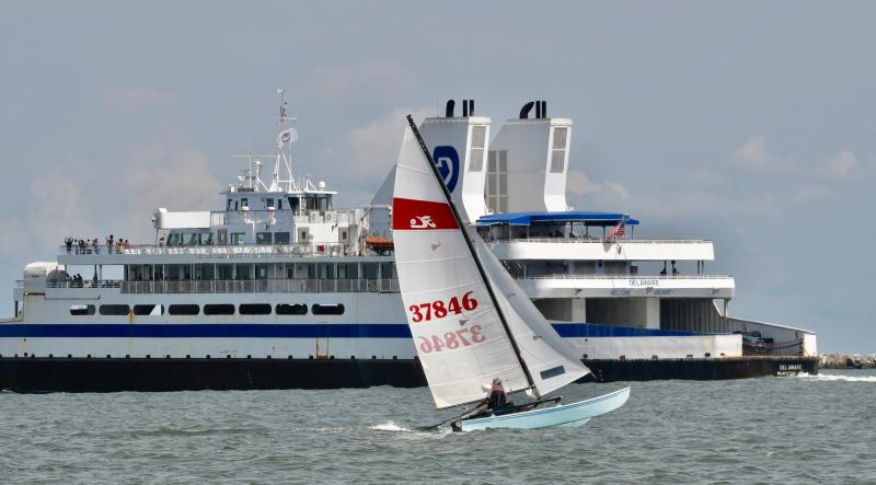 Andy McDonald’s Hobie Cat is dwarfed by the Cape May-Lewes Ferry in the distance. McDonald was the first overall finisher in the LYC Labor Day race one-design boat competition.