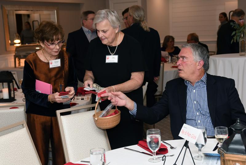Carolyn Marshall, left, and Sue Crawford sell raffle tickets to Gerry Coscia.