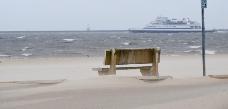 The wind drives sand across the main Lewes Beach parking lot. City crews closed off the front section of the lot because of drifting sand. RON MACARTHUR PHOTO