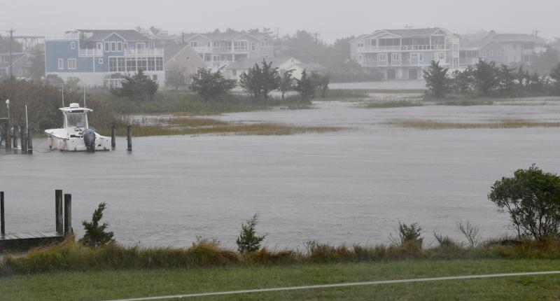 The Lewes-Rehoboth Canal flows over into the marsh adjacent to homes on Cedar Street in Lewes during one of four or five more excessive high tides predicted Oct. 3 and 4. RON MACARTHUR PHOTO
