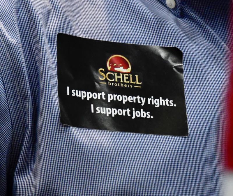 A large contingent of Schell Brothers employees attending the appeals hearing wore stickers in support of property rights and jobs. Schell Brothers LLC is the developer of the Coral Lakes project.