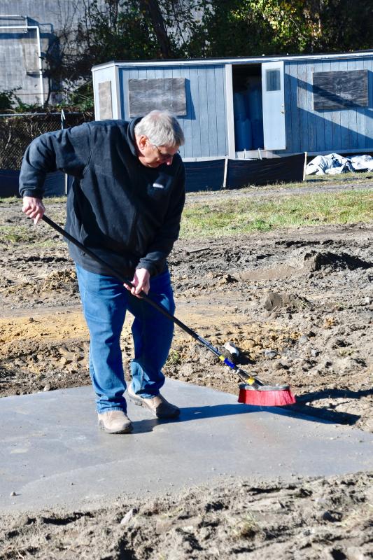 Judson Malone, Springboard Collaborative executive director, gets in on the action by preparing a pad for another shelter unit.
