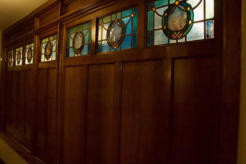 A wall of wood and stained glass is decorative for folks waiting for a table in the common space hallway and for those in the private dining area.