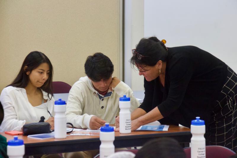 Sherlyn Roblero, left, and Brandon Lopez fill out their resumes with the help of academic coach Jennifer Thompson.