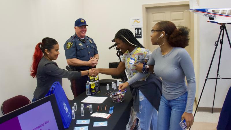 Victim Support Specialist Jessica Rivera and Chief Ralph Holm with the Georgetown Police Department interact with Talayah Showell and Jahzyia Johnson.