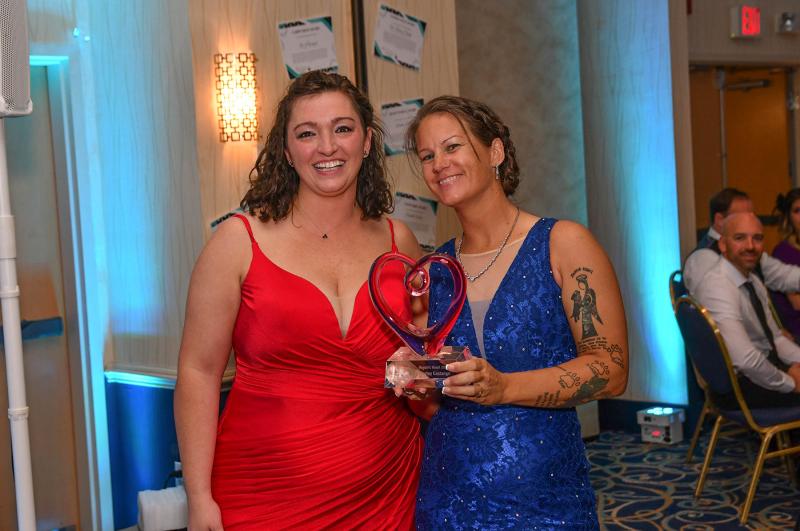 Grass Roots Rescue Executive Director Karli Crenshaw presents Marley Costango with the 2022 Hooch’s Heart Award.