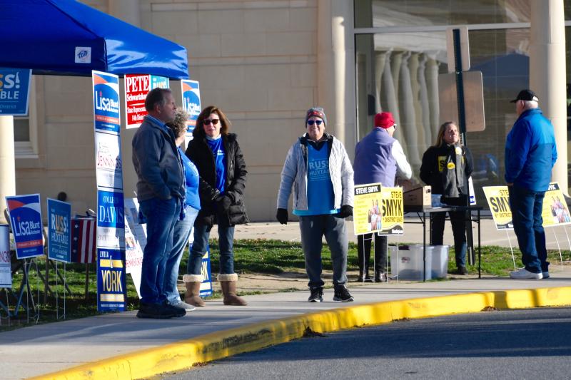 Supporters of Democrat Russ Huxtable and Republican Steve Smyk, running for the Senate District 6 seat, work for their candidates in front of the polling place at Cape Henlopen High School. RON MACARTHUR PHOTO