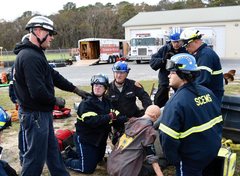 Rescue Tech trainer Mark Taluba, left, offers suggestions to a group of Sussex County paramedics during a simulated auger farm accident. They are (l-r) Stephanie Forbes, Matt Dotterer, Alan Jarmon, Brandon Donaway and Alejandro Zambrano.