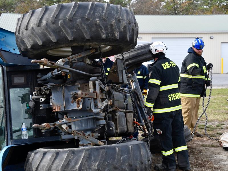 Sussex County Technical Rescue Team members Curtis Stephens, left, and Josh Perrine make preparations to lift a tipped-over tractor.