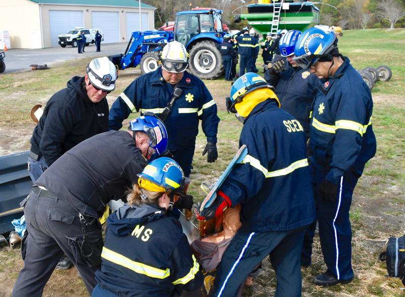 As paramedics work to stabilize a “victim” with his arm stuck in an auger, others begin to carefully cut away the metal pipe.