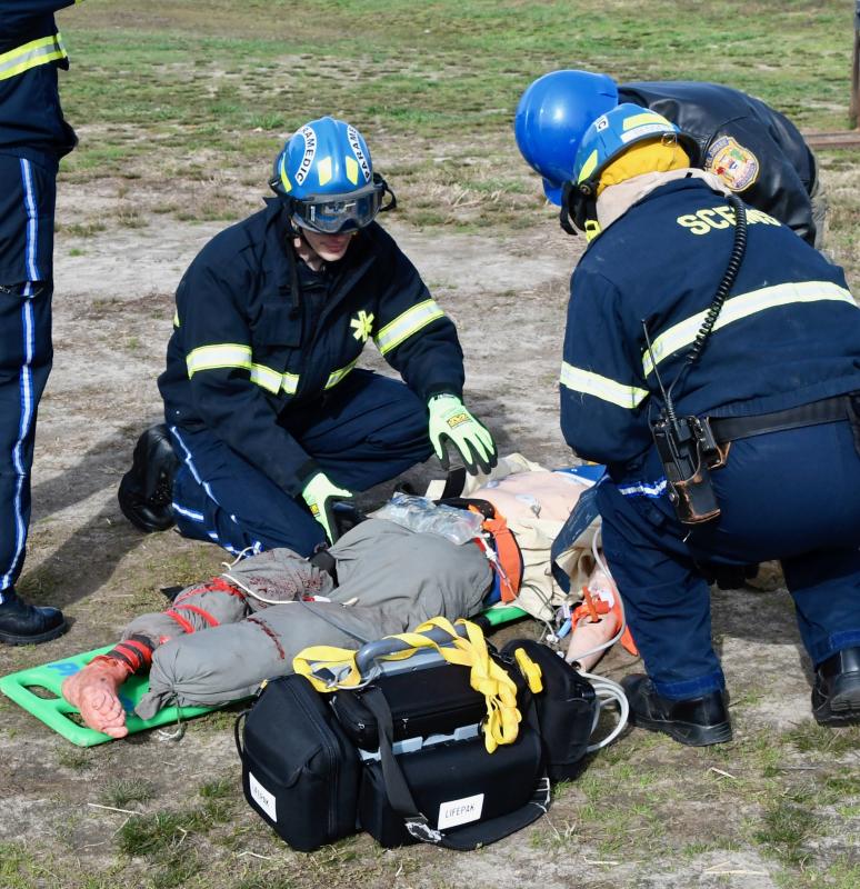 Assessing a “victim” just removed from an overturned tractor are (l-r) paramedic Matt Jankovic, DSP aviation unit member Matt Pragg and paramedic Keith Bennett. Overturned tractors are the most common farming accident.