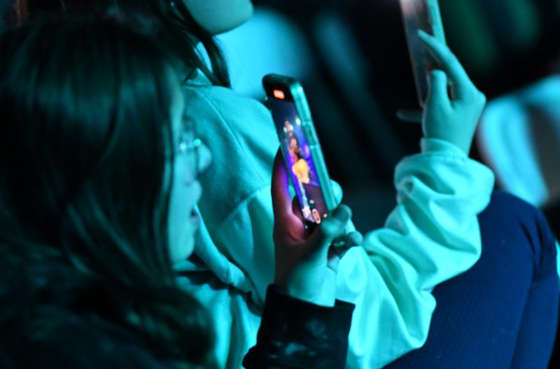 A young fan captures a video to remember.