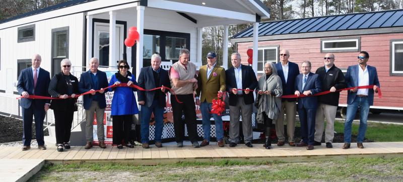 A large crowd takes part in the ribbon cutting to officially open Great Outdoor Cottages in the Delaware Coastal Business Park. They are (l-r) Sussex County Administrator Todd Lawson; Becky Carney, chamber member; Sussex County Councilman Doug Hudson; Sarah Gilmour, chamber board member; Sussex County Councilman John Rieley; Chief Operating Officer Mike Scheid; Todd Burbage, co-owner Great Outdoor Cottages and CEO of Blue Water Development Co.; Chief Financial Officer John Longino; Georgetown Councilwoman Christina Diaz-Malone; Sussex County Council President Mike Vincent; Sussex County Economic Development Director Bill Pfaff; Kurt Herring, chamber member; and Rafael Correa, Great Outdoor Cottages.