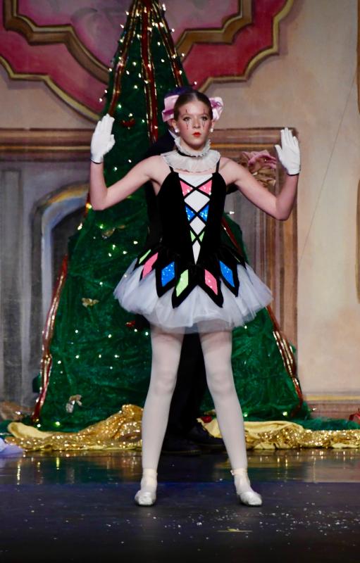Olivia Conaway, as the Columbine Doll, prepares to dance for the party’s entertainment after getting wound up by her owner.