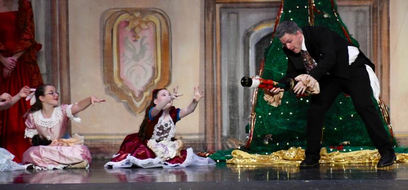 Braeden Swain, as Herr Drosselmeyer, teases the children, including (l-r) Ainsley Rhodes and Priscilla Walker with the Nutcracker.