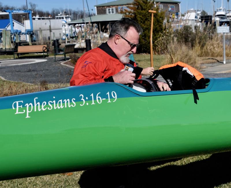 David Schofield, founder and coach of the outrigger ministry club, prepares to go for a year-end paddle, leaving from Canalfront Park in downtown Lewes. The Bible verse on the canoe relates to the idea that God strengthens our inner spirit through the power given to us by the Holy Spirit.