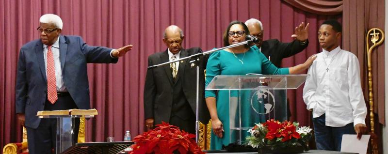 Offering a blessing for Mariner Middle School student Shamir Lambert, far left, are (l-r) the Rev. George Meekins, Bishop A.D. Jones, worship leader Nika Drew Reid and the Rev. George Edwards. Lambert read an essay he wrote stating the purpose of the MLK celebration.
