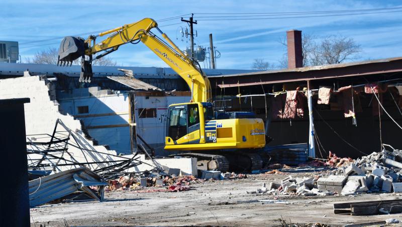 DAY 2. Early on Jan. 18, the second day of demolition, a John Macklin & Son excavator rips off roof sections of the former Bests’ Ace Hardware store along Route 1 at Five Points near Lewes. RON MACARTHUR PHOTOS