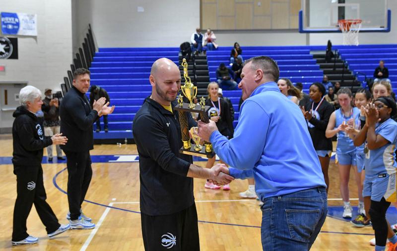 Cape coach Pat Woods receives the Henlopen Conference Championship trophy from Cape Superintendent Bob Fulton.