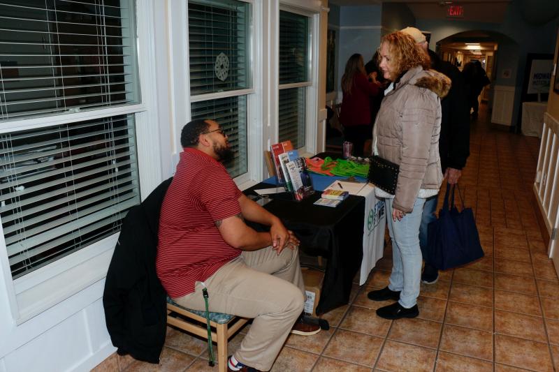 Tyrell Jackson lets Linda and Jim Atkinson know about the Stand By Me financial outreach offered from United Way.
