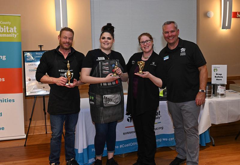 Sussex Habitat CEO Kevin Gilmore, right, presents the awards for the favorite entrees. Shown are (l-r) Adam Linder, first place; Kacie Pinnock, second place; and Allison Foshee, third place.