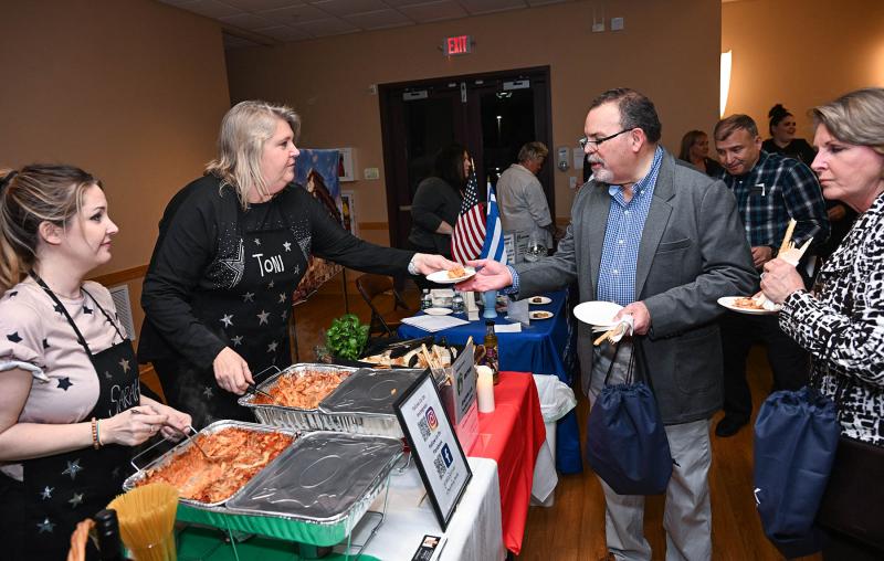 Sarah Mooney and Toni Schrock serve up Schrock’s dish of Poor Man’s Lasagna to Joaquin and Gemma Cabrera.