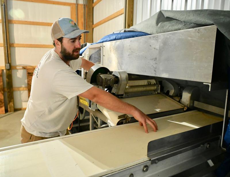 Henry Bennett demonstrates how the farm’s blueberry cleaning and sorting machine works. It’s the only machinery used during the picking of blueberries and peaches.