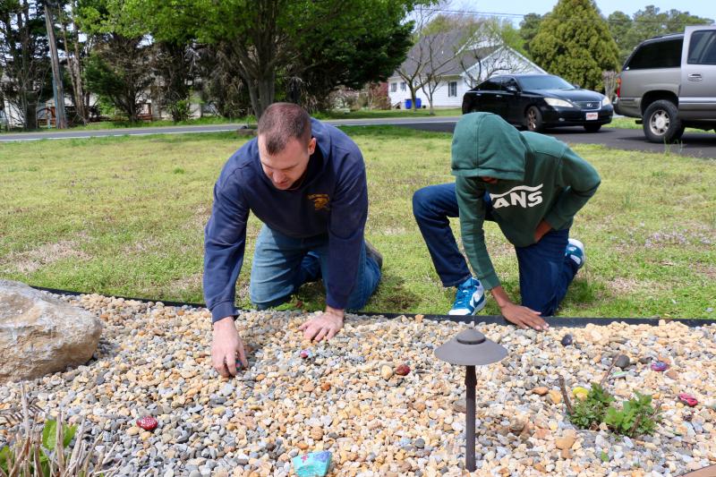 Daniel Nelson helps Gio Jean-Louis check to make sure they have gotten all the weeds out of this section of the memorial.