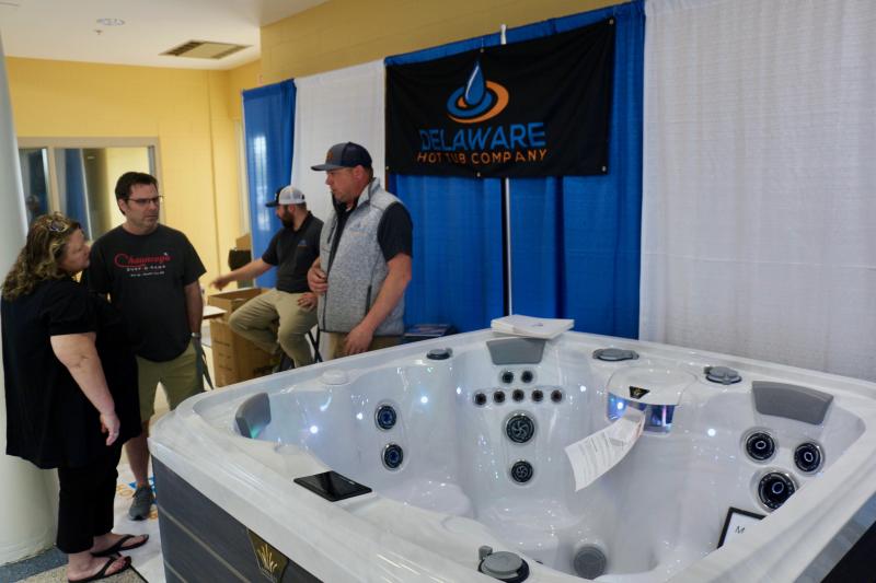 Carol and Karl Strootman listen to the sales pitch of Delaware Hot Tub Company’s Tony Romanelli while Brendan McKinney takes notes in the back.