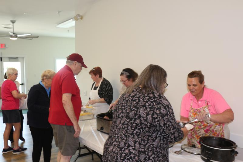 Having to wear the hat of the servee for a change, volunteers were served meals by Lewes Senior Activity Center staff. In the apron serving her homemade baked macaroni and cheese is Executive Director Tricia Fleming while Kate O’Rourke dishes out the ham and Joanne Murphy makes sure volunteers get green beans.