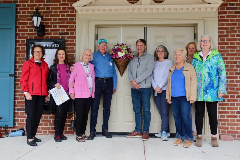 Members of Lewes in Bloom who worked to make the May Day celebration possible pose with Mayor Andrew Williams during a basket-hanging ceremony April 24. Shown are (l-r) Terry Yates, Maureen Iciano, Pam Meador, John Roecker, Mayor Andrew Williams, parks and recreation commission Chair Janet Reeves, Bonnie Mahr, Patti Walters and Meg Walsh. AARON MUSHRUSH PHOTO