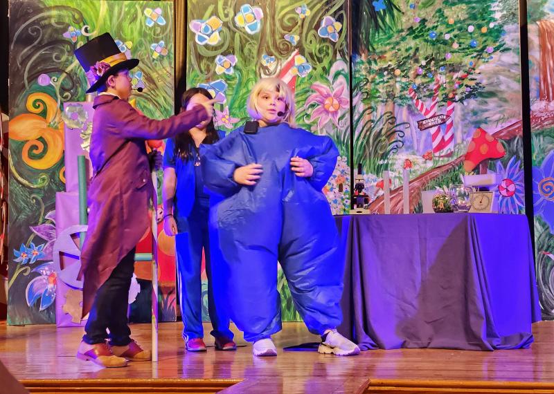 Charlie Albitz as Willy Wonka reacts as Bella Hittle, portraying Violet Beauregarde, begins to swell.