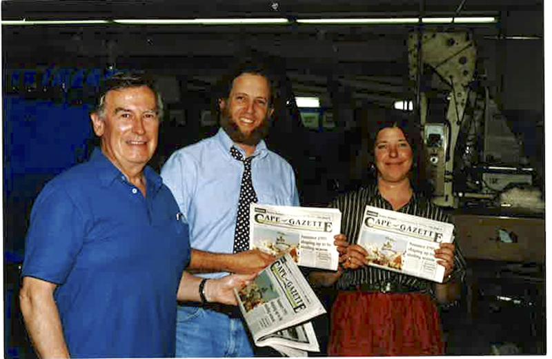 Dennis Forney, center, stands with Trish Vernon and former Dover Post Printing Co. President Jim Flood Sr. holding the first edition of the Cape Gazette, which hit newsstands May 28, 1993. FILE PHOTO