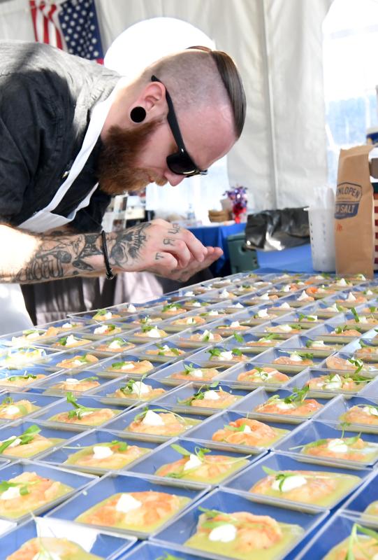 Chef Dillon Walker of Lewes Oyster House puts the finishing touches on a dish of cucumber, tomatillo, avocado gazpacho with sazon, poached shrimp, cilantro lime creme fraiche and Henlopen sea salt.