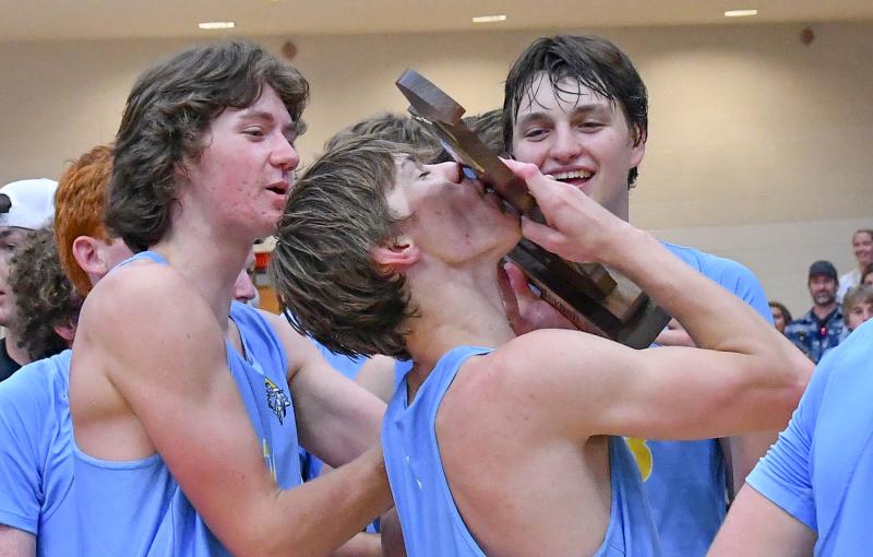 Cape captain Talan Stephens gives the DIAA trophy a smooch while teammates Billy Cerf and Odin Potemski await their turn.