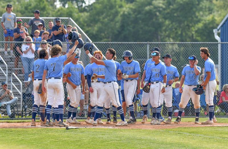 Cape junior catcher Brenn Scott is welcomed at home after his three-run homer in the third.