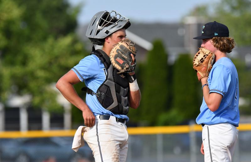 Catcher Brenn Scott, left, makes sure of a pitch with Jaxon Clampitt.