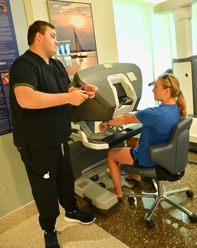 Darby Klopp, an off-duty Beebe emergency room nurse, gets instructions on how to control the robotic arms from Brody Hastings of Intuitive Surgical, the company that manufactures the robotic systems.