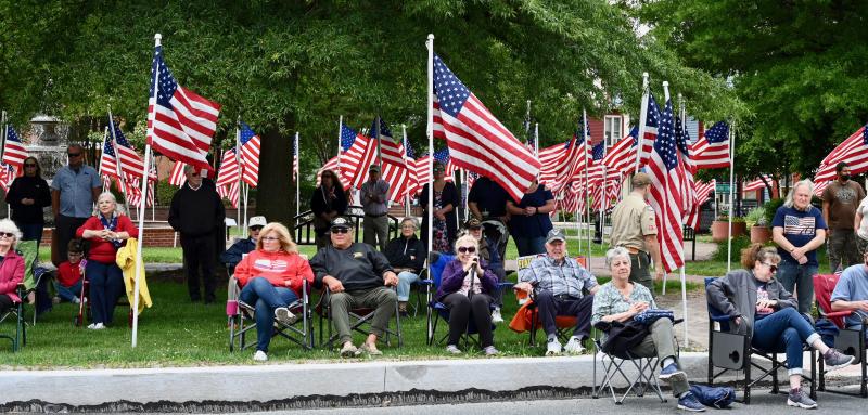 A crowd gathers around The Circle among the Rotary’s Flags for Heroes to honor fallen service members.