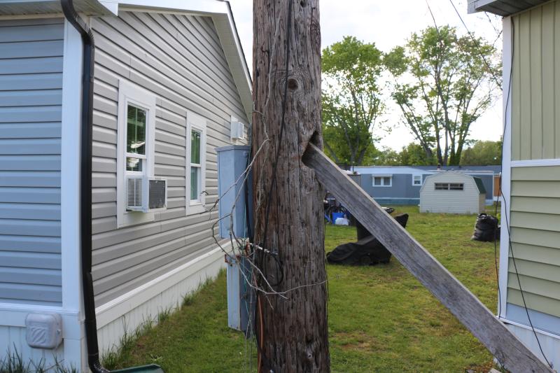 A resident of Donovan Smith Manufactured Home Park observed an electric pole swaying in the wind. They took it upon themselves to stabilize the pole by using a piece of lumber that fit into a hole on the backside.